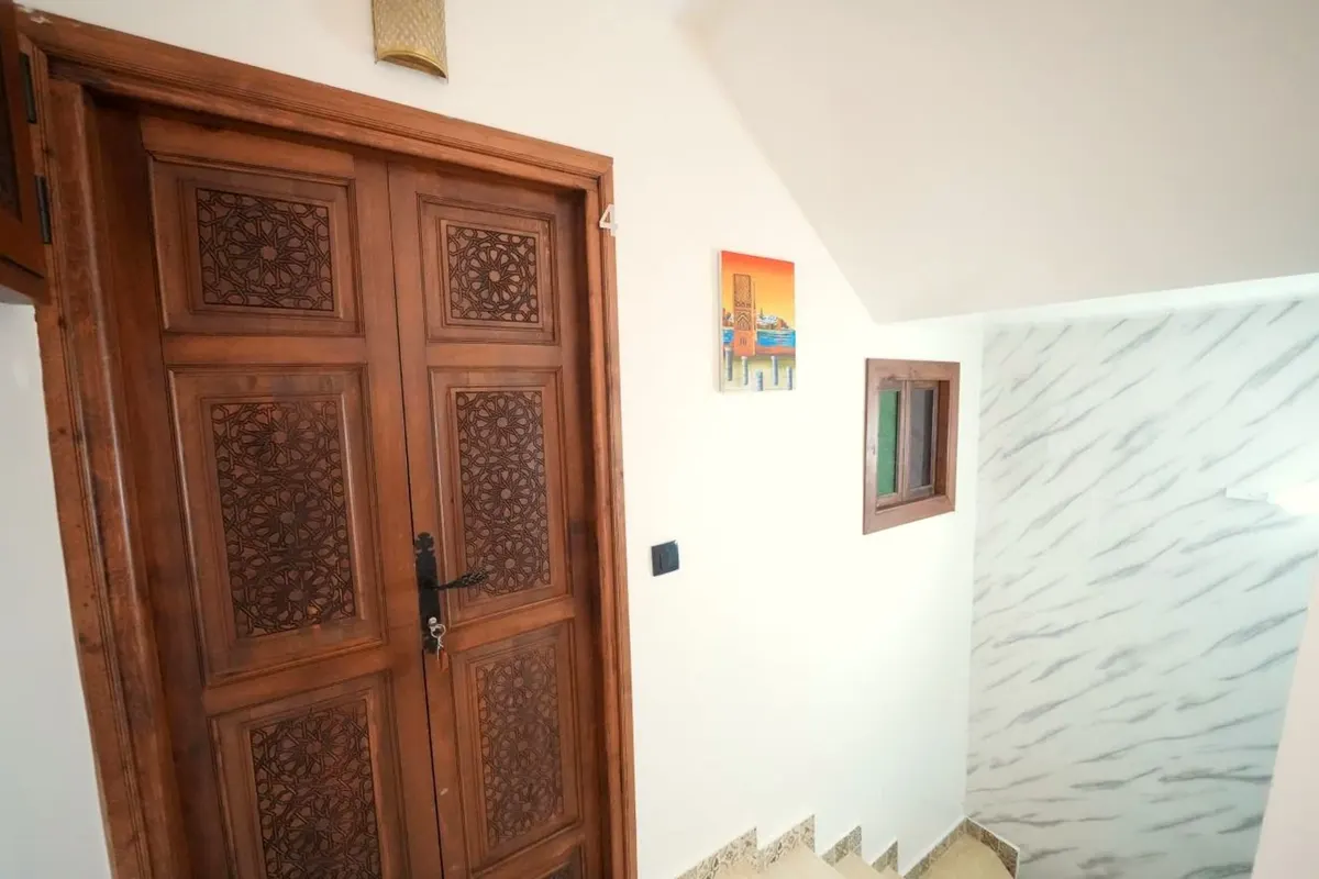 Un palier : portes sculptées, petite fenêtre au cadre vert