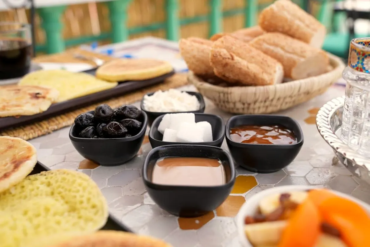 Basket of breads, harcha, dips, olives and fruit salad