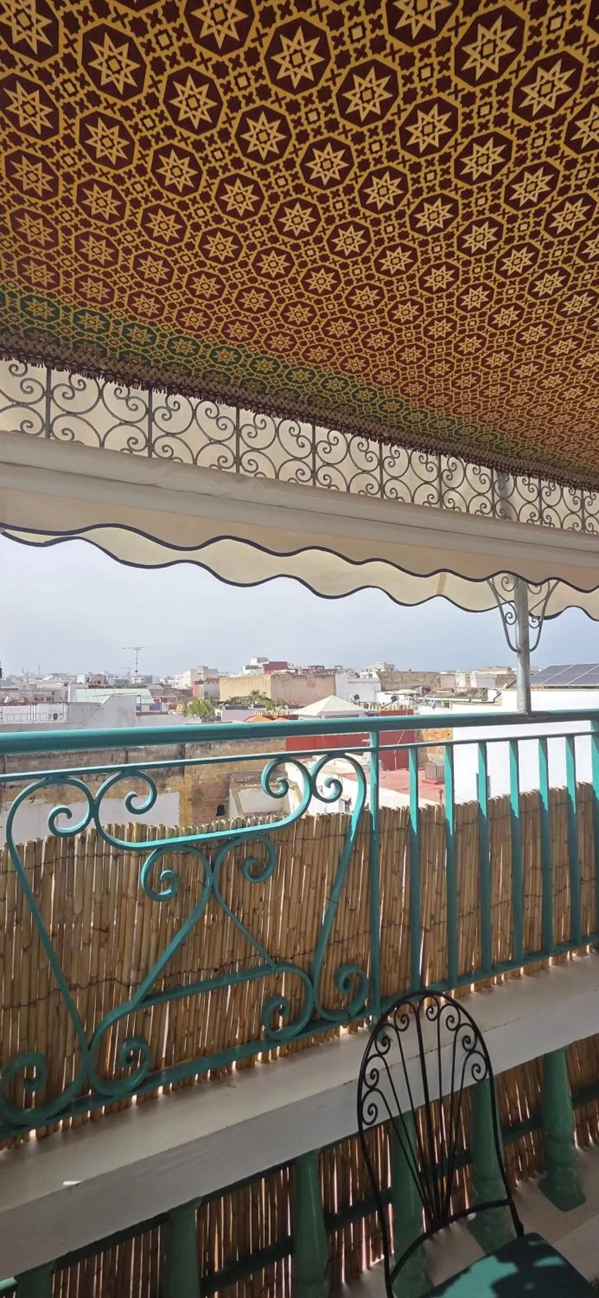 Un coin de la terrasse, ferronneries vertes, vue sur les toits