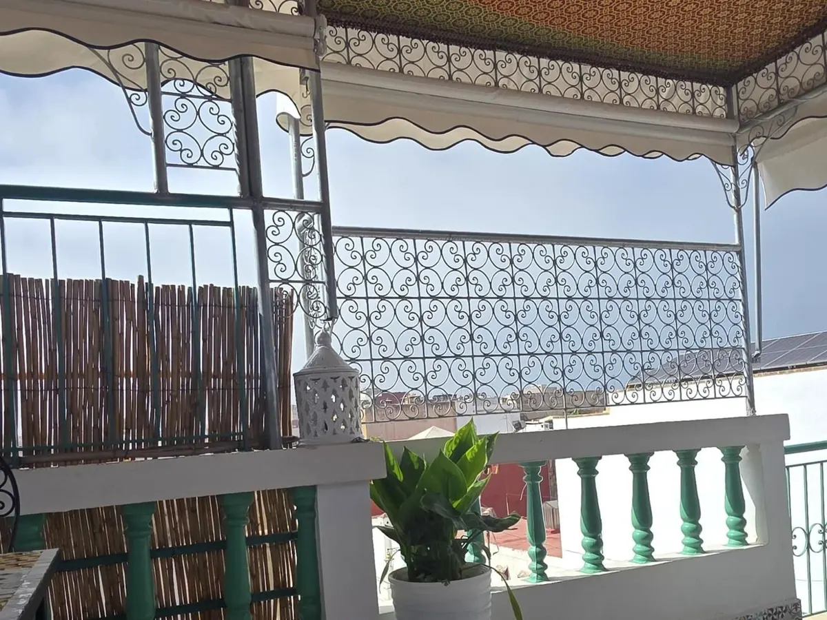 Balustrade with white balusters, green iron, reed screens and a lantern