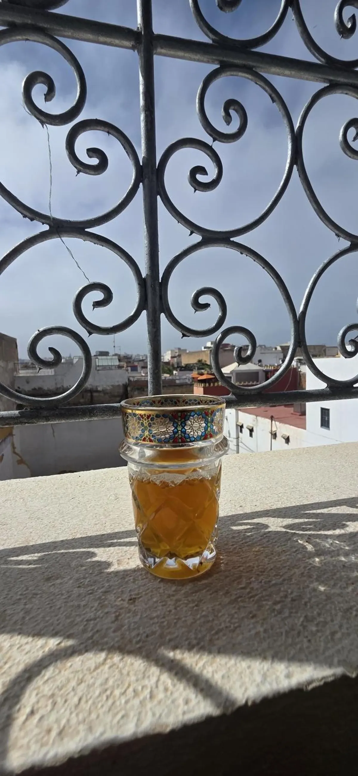 A glass of mint tea on the parapet behind the wrought iron