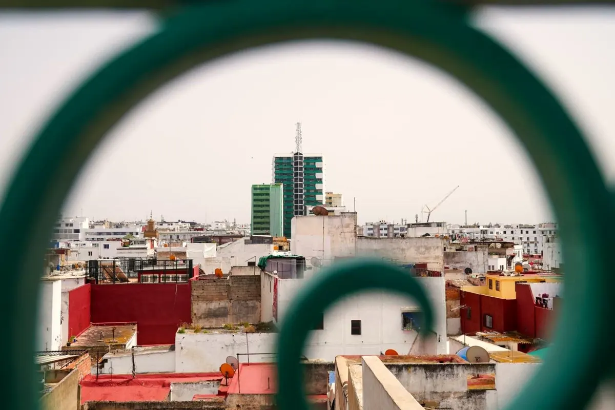 The city seen through a curl of green ironwork