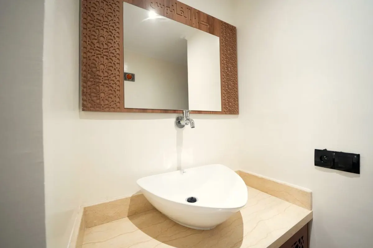 Salle d’eau de la chambre simple : vasque sur plan effet marbre, miroir en bois sculpté